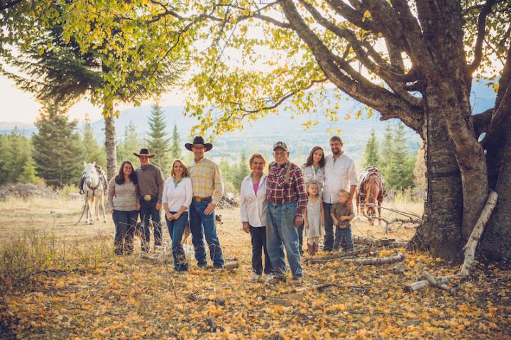 Group of multigenerational people under a tree some wearing cowboy hats